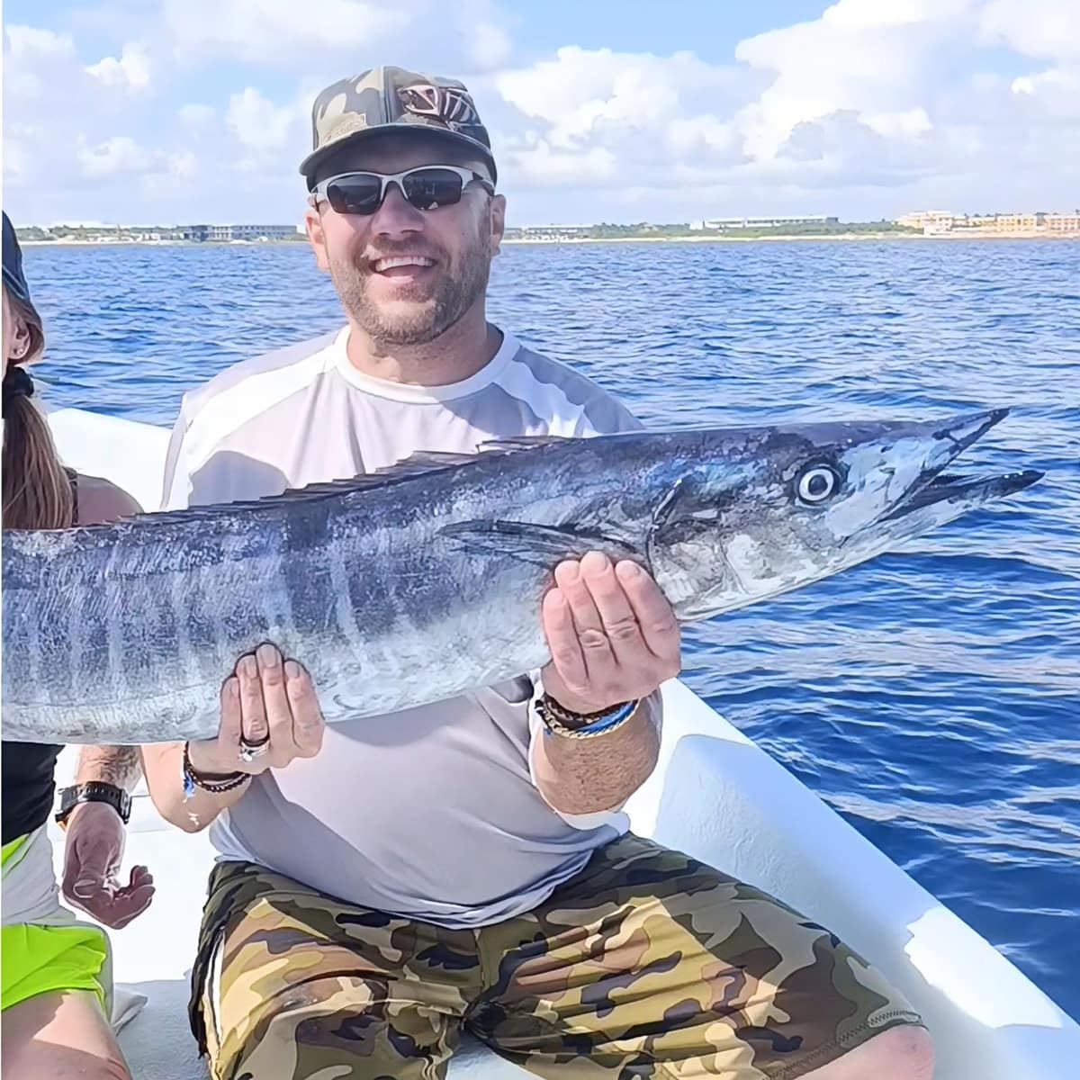 Client holding a wahoo caught on private fishing charter in the Mexican Caribbean
