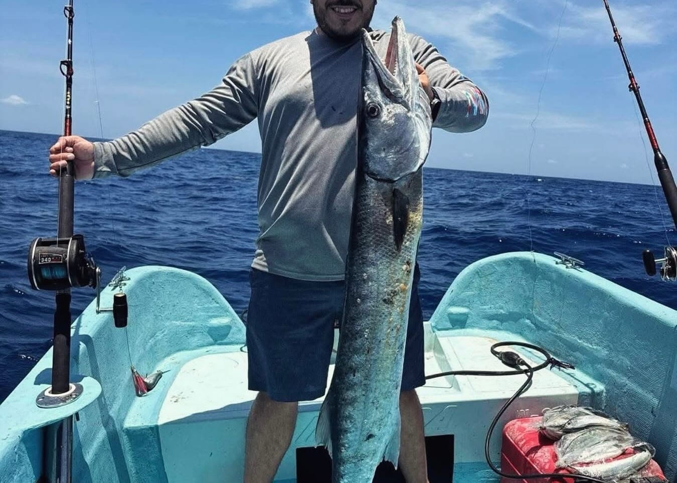 Angler standing on the boat with a long fish just caught