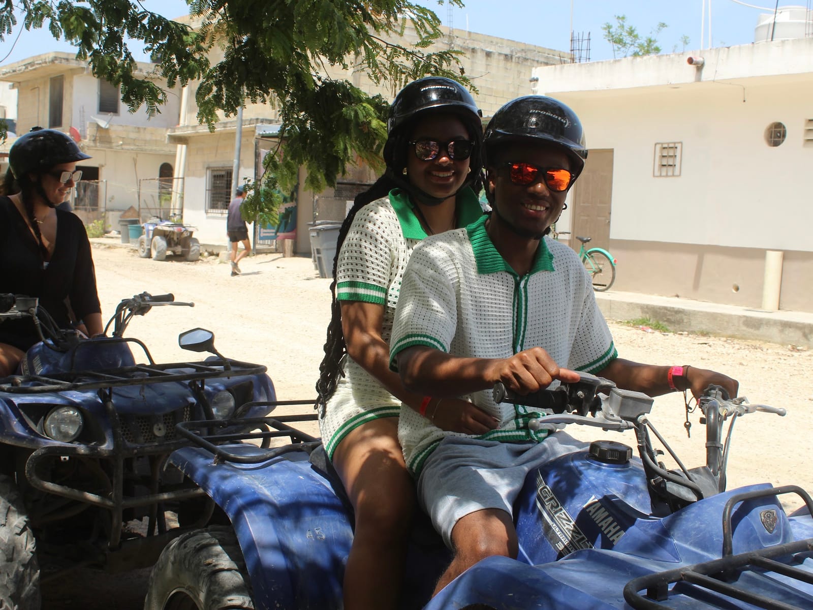 Couple in helmets setting off on a double ATV