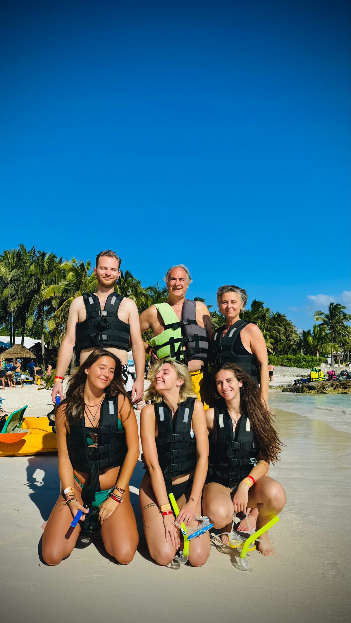 Group of six guests in life vests ready for sea turtle snorkel tour on Akumal beach